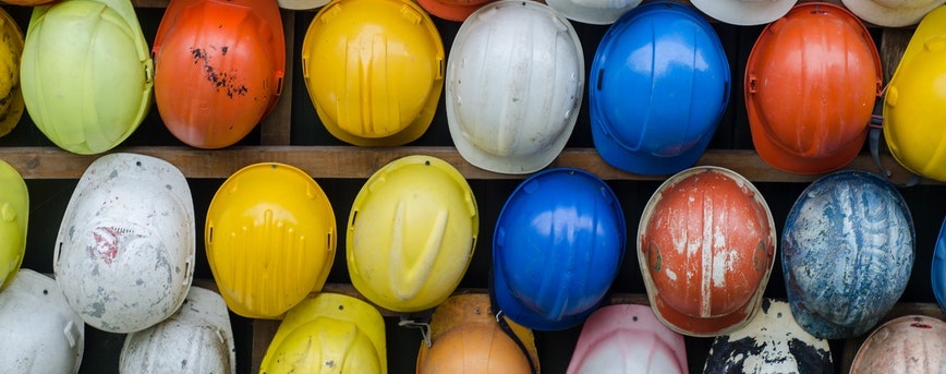 photo of multi-coloured hard hats, view from above