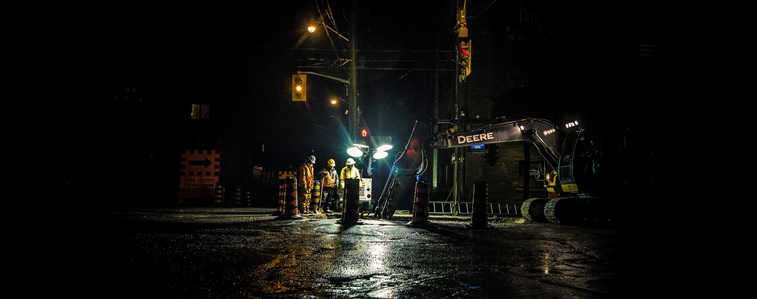 Crew of public works staff working on roadway at night