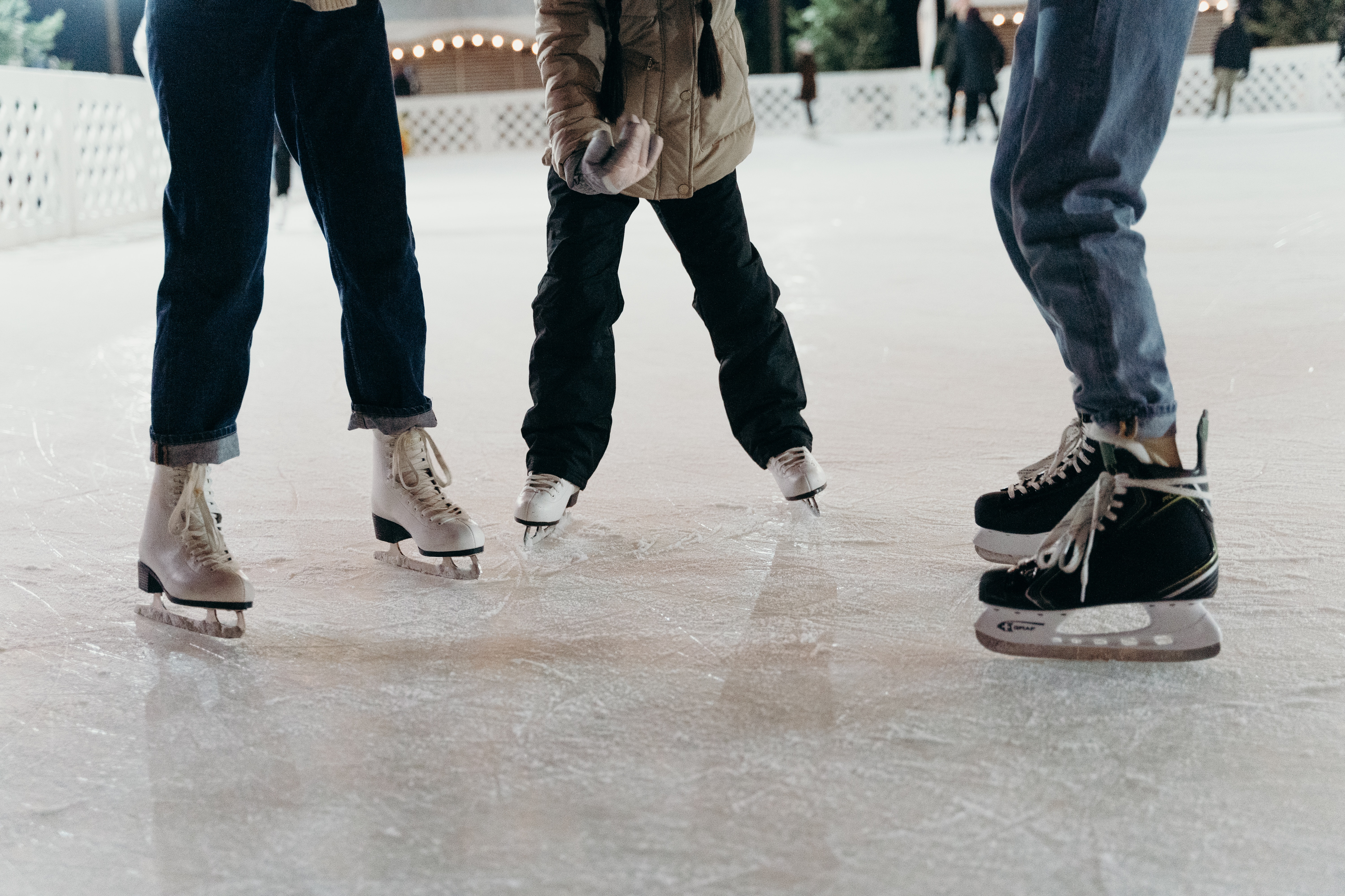three people ice skating