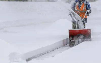 snow blower clearing sidewalk 